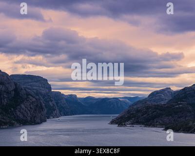 Luce mattutina mozzafiato e vista sul Lysefjord nel sud-ovest della Norvegia, circondato da ripide scogliere, paesaggi di montagna spettacolari, sotto una guerra Foto Stock
