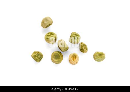 Semi di pisello verde asciutti sparsi su uno sfondo bianco pulito. Vista dall'alto della piantagione di semi di pisum sativum organici rugosi Foto Stock