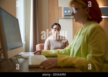 Donne di mezza età e giovani che collaborano in un ufficio Foto Stock