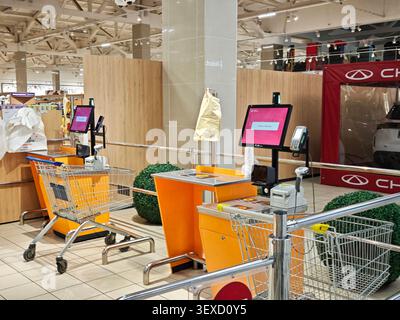 Kirov, Russia - 8 febbraio 2026: I clienti utilizzano i chioschi self-checkout in un supermercato mentre i carrelli della spesa sono nelle vicinanze per una facile scansione dei negozi di alimentari. Foto Stock