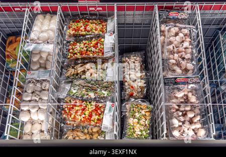 Italia - 30 giugno 2026: Ampia selezione di frutti di mare surgelati confezionati, tra cui seppie, polpo, gamberetti e insalata mista di pesce con verdure, ordinata Foto Stock
