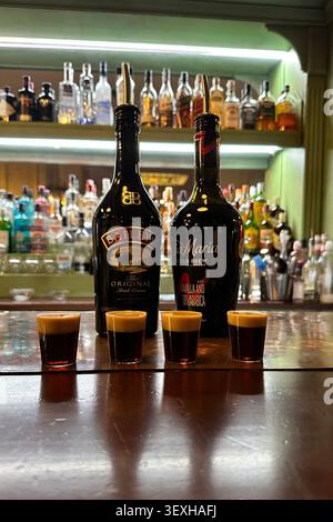 Bottiglie di Baileys Irish Cream e liquore al caffè Tia Maria con shot a strati su un bancone del bar in un cocktail bar. Solo per uso editoriale. Valencia, Spagna Foto Stock