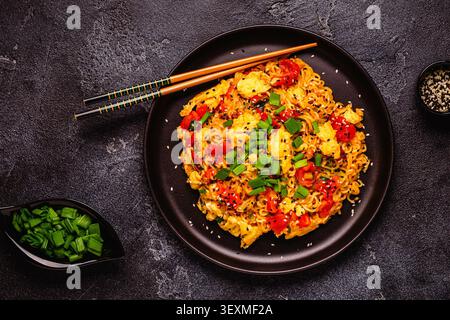 Spaghetti istantanei in stile coreano, Shin Ramyeon con pomodori e uova strapazzate, vista dall'alto. Foto Stock