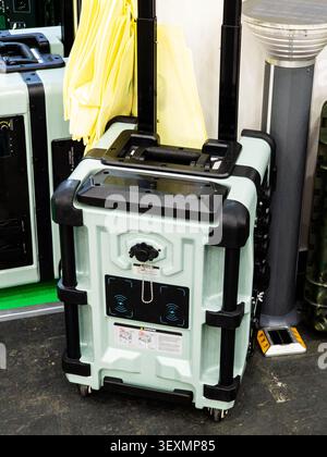 Una centrale elettrica portatile ad alta capacità con un robusto esterno verde menta, un manico telescopico e due pad di ricarica wireless, progettata per Foto Stock