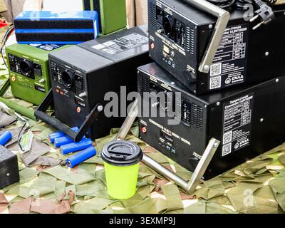 Ucraina, Kiev - 26 maggio 2026:IA raccolta di centrali elettriche portatili per impieghi pesanti e batterie al litio esposte su una rete mimetica militare, show-cas Foto Stock