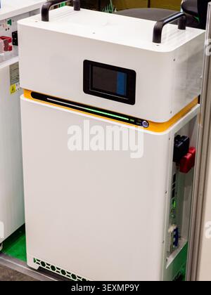 Un sistema di stoccaggio di batterie bianche agli ioni di litio ad alta capacità per backup e gestione di energia solare residenziale o commerciale. Foto Stock