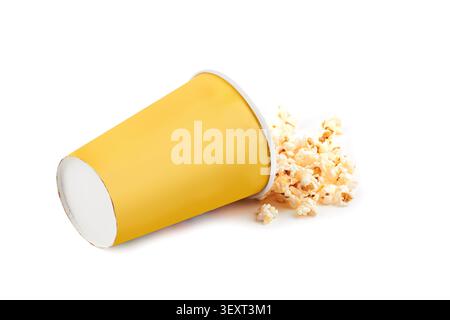 Popcorn sparso dal secchio giallo isolato su fondo bianco Foto Stock