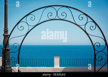 Arco in ferro battuto che incornicia l'orizzonte del Mar Mediterraneo ad Altea, Alicante Foto Stock