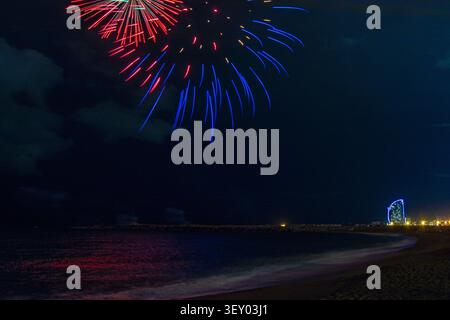 Fuochi d'artificio sulla spiaggia di Barcellona. Una notte d'autunno. Foto Stock