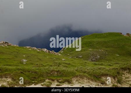 Nuvole di tempesta drammatiche si aprono al crepuscolo su un mare calmo vicino a Cliff Beach (Cliobh), Isola di Lewis, Ebridi Esterne, Scozia. Foto Stock