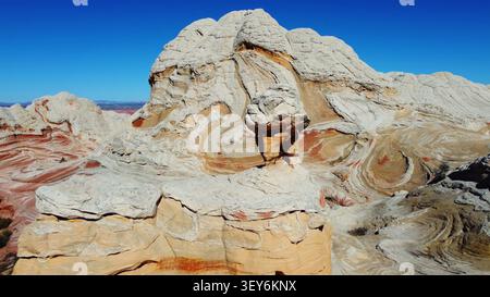 Formazioni di arenaria bianca con strati vorticosi. Spettacolari formazioni di arenaria bianca con strati di colore rosso e marrone scuro, creste arrotondate scolpite, a. Foto Stock