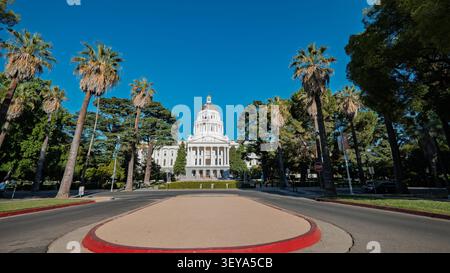 SACRAMENTO, CA - 30 GIUGNO 2026: Il Campidoglio della California è visto dall'altra parte della strada incorniciato da alte palme Foto Stock