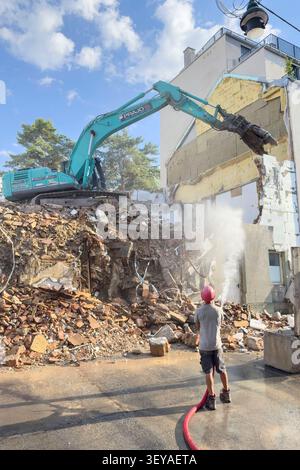 Un grande escavatore cingolato sta demolendo un edificio residenziale nel distretto di Viennas Meidling. Foto Stock