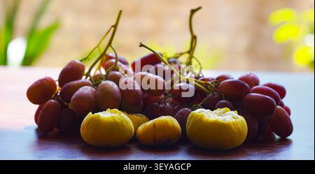 Uva e fichi, uva rosa e fichi gialli in tavola Foto Stock