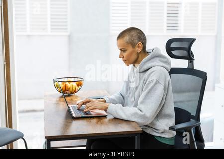 Nutrizionista donna che lavora su un computer portatile in un ufficio moderno Foto Stock