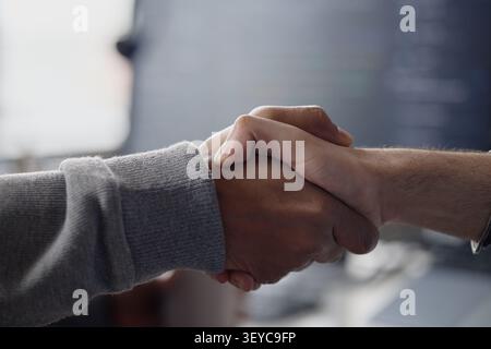 Colleghi di lavoro adulti che stringono la mano all'ufficio delle tecnologie dell'informazione Foto Stock