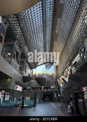 Spettacolare vista interna del monumentale atrio a reticolo in acciaio della stazione di Kyoto, Kyoto, Giappone. Atrio multilivello con filtraggio della luce naturale Foto Stock