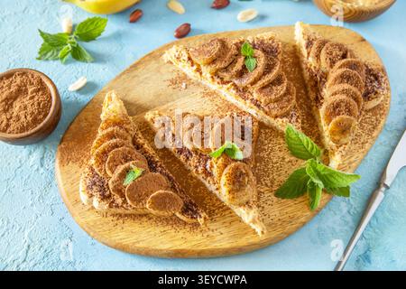 Tostare il pane con burro di arachidi e banana fritta su una superficie di pietra blu. Gustoso dessert pronto da mangiare. Foto Stock