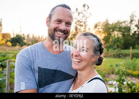 Coppia gioiosa che rideva insieme in un giardino Foto Stock