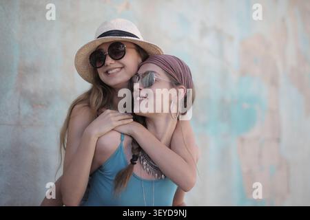 La giovane donna felice dà al suo migliore amico un giro in piggyback Foto Stock
