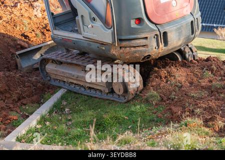 Primo piano dei cingoli dell'escavatore pesanti e contrappesi pesanti, che mostrano la solida struttura del macchinario Foto Stock