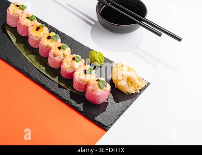 Panini di sushi al forno con tonno piccante, microgreen, zenzero, wasabi e salsa di soia su una tavola di ardesia Foto Stock