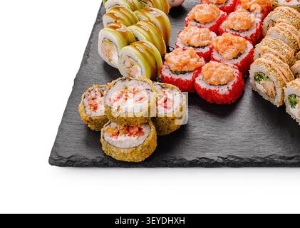 Vari tipi di panini di sushi e maki tradizionali giapponesi serviti su sfondo di pietra scura Foto Stock