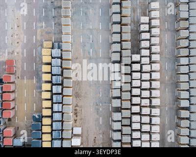 Vista aerea di una fabbrica di lastre di pietra con file di blocchi di cemento colorati impilati in un cantiere industriale di riga, Lettonia. Foto Stock