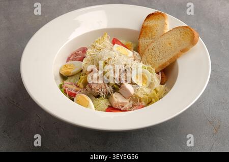 Insalata di pollo fresca con uova sode, fette di pomodoro, formaggio grattugiato e pane tostato Foto Stock