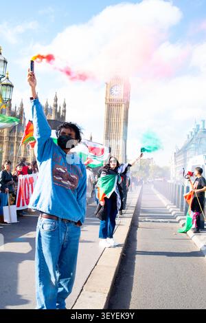 I manifestanti tengono razzi luminosi sul Ponte di Westminster per commemorare lo sciopero delle donne islandesi del 1975 durante una manifestazione pro-Palestina, ottobre 2024 Foto Stock
