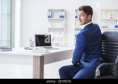 Giovane imprenditore facendo sport stretching al lavoro Foto Stock