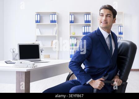 Giovane imprenditore facendo sport stretching al lavoro Foto Stock