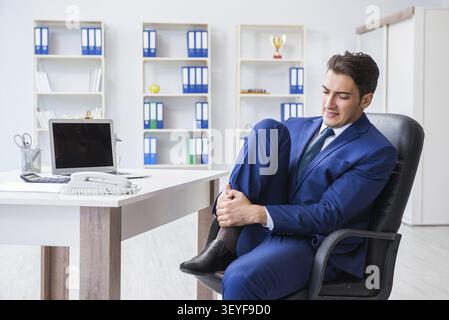 Giovane imprenditore facendo sport stretching al lavoro Foto Stock