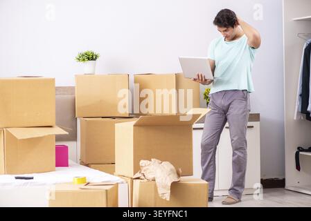 Giovane uomo che si muove di nuovo appartamento Foto Stock