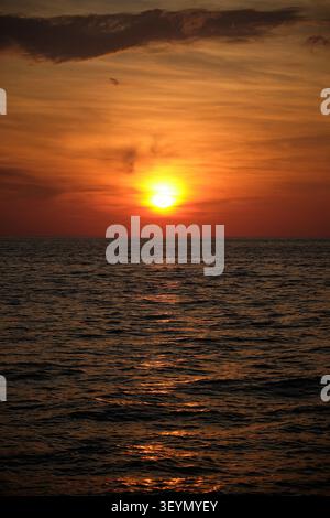 un crepuscolo rosso al tramonto sullo skyline del mare in una scena marina verticale Foto Stock