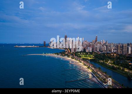 skyline di chicago illuminato al crepuscolo dalla vista aerea sul lago michigan con un'atmosfera serena e vibrante caratterizzata da grattacieli in cemento, vetro e metallo Foto Stock
