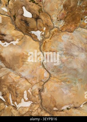 Vista aerea di Kerlingarfjoll con aspre montagne geotermiche, torrenti tortuosi e macchie di neve negli altopiani di Hrunamannahreppur, Islanda. Foto Stock
