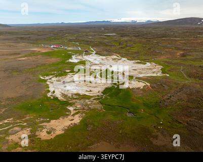 Vista aerea dell'area geotermale di Hveravellir con passerelle in legno che si snodano attraverso piscine fumanti e un vivace terreno di muschio verde nelle terre vulcaniche Foto Stock