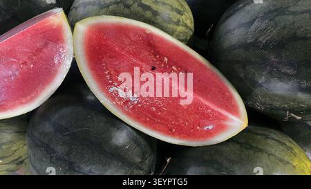 Anguria intera fresca con buccia verde striata naturale, raccolta e pronta da mangiare. Foto Stock