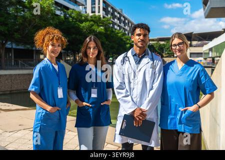 Team di personale medico diversificato in piedi all'aperto che collabora per l'assistenza sanitaria Foto Stock