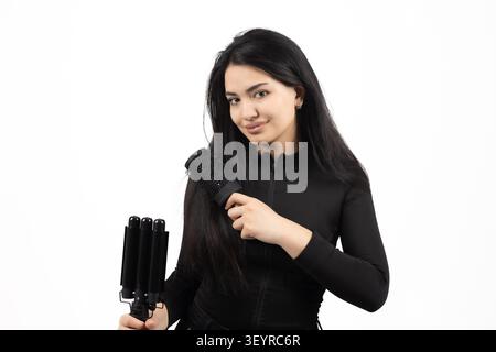 Donna che pulisce i capelli con un ferro da stiro professionale in una foto professionale stu... Foto Stock