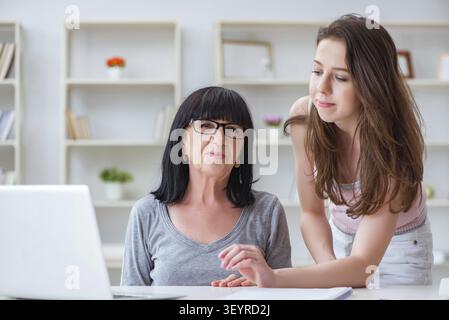 Figlia di spiegare alla mamma come usare il computer Foto Stock