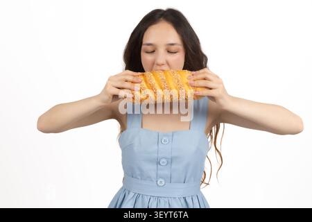 Giovane donna che tiene un grande hamburger con entrambe le mani in una foto professionale... Foto Stock