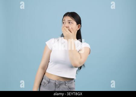 Sorpresa giovane donna che guarda da parte a bocca aperta in una foto professionale... Foto Stock