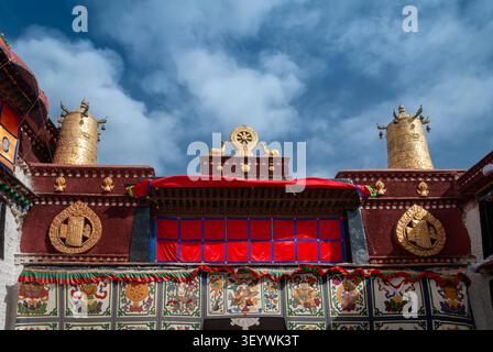 Ruota dorata del Dharma e bandiere della vittoria sul tetto del tempio Jokhang, un sito del patrimonio mondiale UNESCO a Lhasa, Tibet Foto Stock