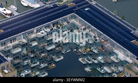 Vista aerea dell'edificio Sluishuis caratterizzato dal suo caratteristico design a sbalzo, pannelli solari e balconi che si affacciano sull'acqua ad Amsterdam, N Foto Stock