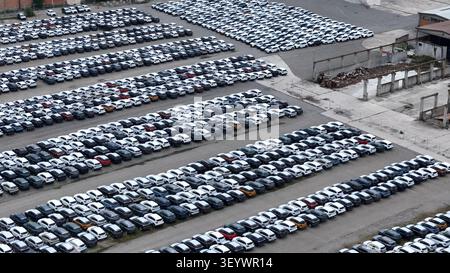 Nuove auto suv parcheggiate in fila in un ampio deposito automobilistico, che mostra la distribuzione su larga scala dei veicoli, la logistica di importazione ed esportazione Foto Stock