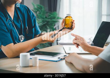Medico che spiega la bottiglia di farmaco da prescrizione a un paziente durante la visita clinica, consultazione sanitaria, farmacia, consigli di dosaggio, trattamento, e pa Foto Stock