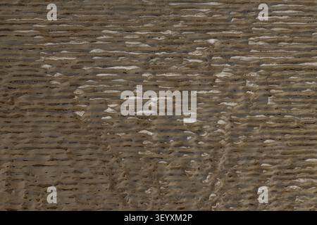 Onde orizzontali di sedimenti minerali in una sorgente termale. Texture a strisce creata dal flusso di acqua geotermica, simile alle onde di sabbia sul fondale marino. In alto Foto Stock