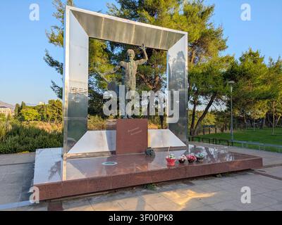 PODGORICA, MONTENEGRO - 25 agosto 2025: Il monumento di Vladimir Vysotsky a Podgorica, con una statua in bronzo di un uomo con una chitarra all'interno di un grande Met Foto Stock